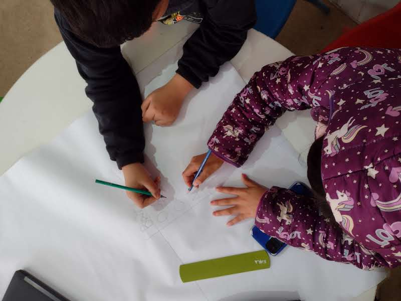 Manos de niñas y niños aprendiendo juntos